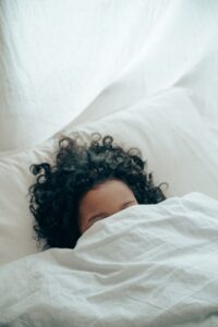 girl sleeping with covers over face